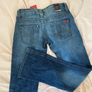 Y2k jeans straight/flaired lågmidjade - Y2k jeans från 90-talet. Helt oanvända prislappen kvar. Köpt från annan men säljer då de var för små för mig i midjan. Dessa är i storlek 26, passar även 25 men var för små för mig som vanligtvis använder storlek 27. De var väldigt långa och bra i längden (jag är 170). Väldigt snygg straight/ flaired passform, jätte bra kvalité. Kan mötas upp i stockholm (jag bor i sköndal), annars står köparen för frakt. Bud från 300 kr (buda i kommentarsfältet). Avslutas fredag 30 juli.