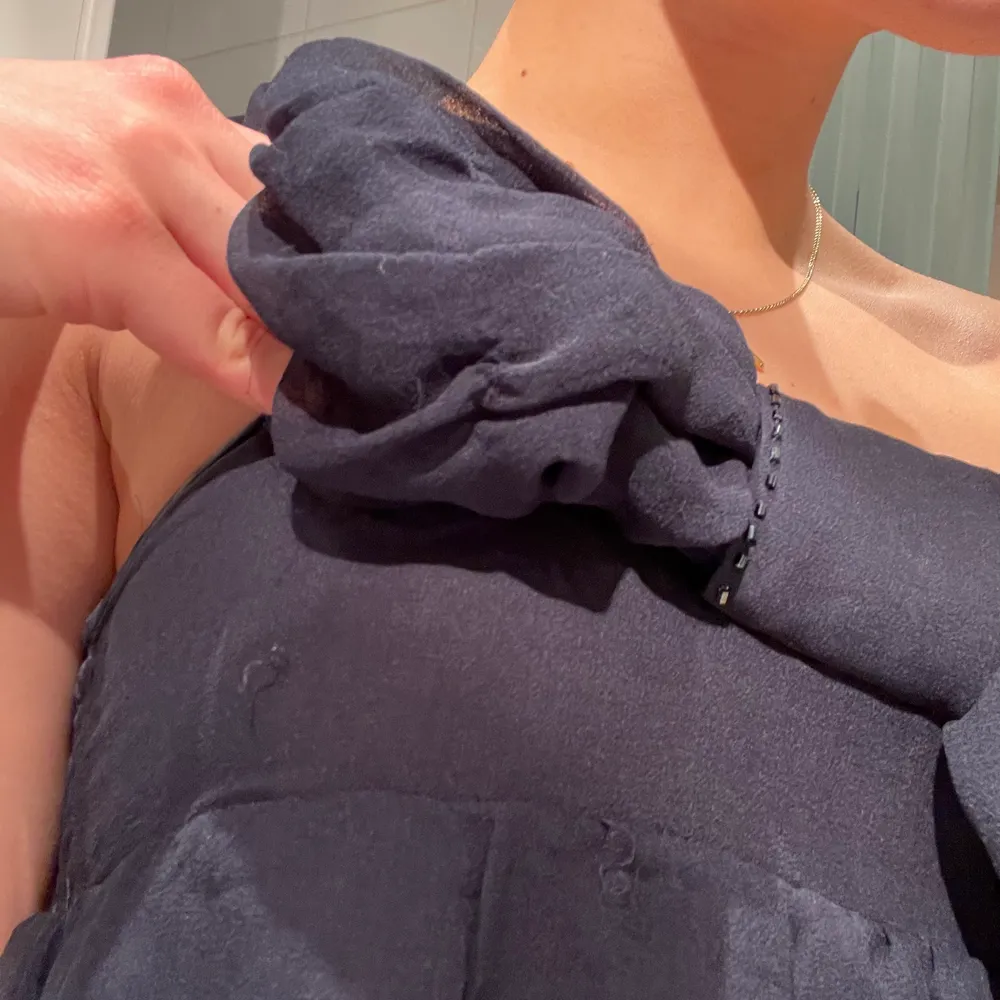 Mörkblå silkesklänning från ”Dino e Lucia”. Den är i 100% silke och köpte för ca 1500kr. Den är i storlek 12, vilket jag uppskattar som en XS. Den är i väldigt fint skick förrutom 2 trådar på bröstet(se sista bild), men detta täcks av rosetten och syns ej. Klänningar.