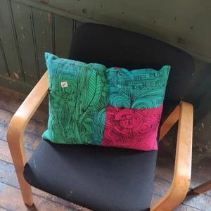 Kudde - Färgglad kudde! Säljer då den inte kommer till användning. I nyskick. Osäker om måtten men ca 15x40cm. Säljer även andra deckorationer, kläder, böcker mm