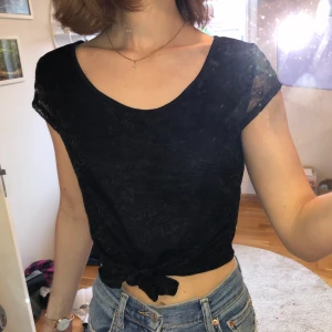 Svart fin tröja med extra detaljer - En enkel men fin tröja man kan knyta längst ner som ger tröjan en extra detalj. Tröjan är även spets.