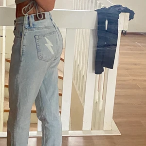 Jeans med detaljer på fickorna  - INTRESSEKOLL på mina älskade låga/ mellan midjade byxor med detaljer på fickorna. Jag har själv målat en vit blixt och stjärna på vardera sida och verkligen älskar dessa jeans. Jag har även klippt en liten slit på insidan av byxorna. Jeansen är i storlek 24 men passar nog någon lite större beroende på hur man vill att de ska sitta 🤍 buda! Säljer bara vid bra bud!