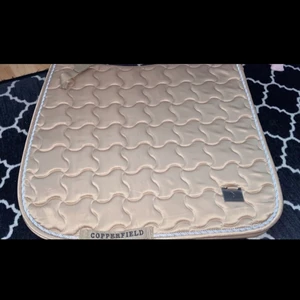 Nytt dressyr schabrak, storlek full - Jag har ett helt nytt schabrak som jag vill sälja eftersom jag råkade köpa ett dressyr schabrak och tyvärr har jag ingen dressyrsadel till min häst därför ingen användning av schabraket. Färgen är jättefin samt modellen.