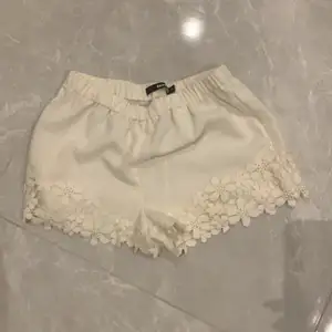 Vita shorts med fint mönstrade kanter