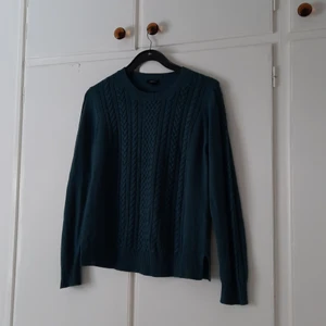Grön stickad långärmad, strl M - En mjuk, mörkgrön/blå långärmad som är stickad. Från Lindex, i storlek M. Den har två slits på sidorna nere på "mudden". Köpt på secondhand, men har aldrig använt den så den får säljas vidare. Pris: 40kr + frakt