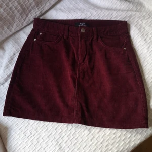 Bershka kjol strl M - Vacker vinröd kjol i manchester från Bershka i strl M, ca 74cm i midjan och 35,5cm lång. Två fejk-fickor där fram, 2 riktiga fickor bak. Rätt varmt material. 