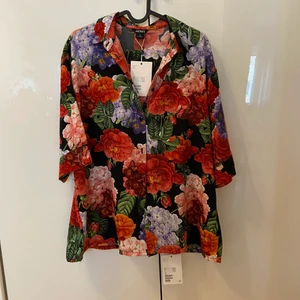 Monki Floral Set, skjorta & byxor  - Säljer ett fantastiskt blommigt set från Monki. Aldrig använt, lappar finns kvar. Skjorta strl S (stor i storleken), byxor strl 38. 300kr för båda två!