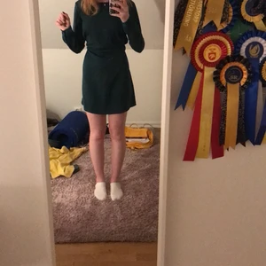 Mörkgrön klänning  - Mörkgrön klänning med tillhörande band (går att knyta på lite olika sätt, fram, bak och går att ta av helt) endast använd vid 1 jul