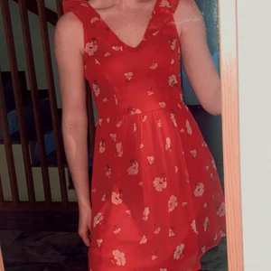 Blommig röd klänning  - Superfin blommig röd klänning som passar super till sommaren. Fina volanger på ärmarna. Oanvänd. Storlek 36. 200 kr eller bud! Köparen står för frakt. 