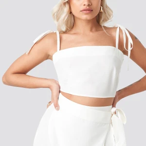 Linne AFJ X NAKD - Ett väldigt sött och fint linne från AFJ x NA-KD! Det har en fin detalj på axlarna. Det är näst in till oanvänt och därför i väldigt bra skick💕 Kom med bud!