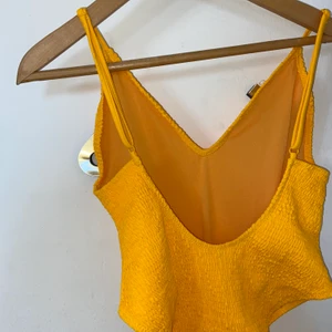 Gul baddräkt, nelly - Oanvänd, gul baddräkt från Nelly med djup rygg och hög midja. Så snygg men passar ej mig tyvärr!! Storlek L men skulle säga att den funkar för M/L🥰 Köparen står för frakt 😇