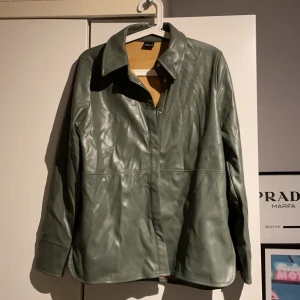 Jacka Gina tricot - Helt oanvänd den är som ny säljer den då jag inte kommer få någon användning av den. Den är lite längre på mej är 164 men sjukt fin modell. I en fin grön färg. Blazer jacka i skinn perfekt till våren