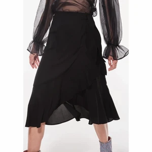 GinaTricot omlottkjol - En svart omlottkjol från GinaTricot. Bilderna är från deras egna hemsida då mina bilder inte gav kjolen rättvisa. Dock har knappen i kjol, det som håller ihop det, gått av. Men jag brukar sätta en klämma och det är inga problem. Använd ett par gånger, men allt annat än knappen så är kjolen i perfekt skick. (Köparen står för frakten) 