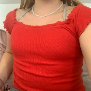 En röd tröja  - En röd tröja men kan ta över axlarna 