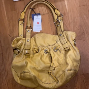 Gul supersnygg väska - Denna väskan köpte jag för 5 år sedan i USA och jag har tyvär inte fått någon användning av den. Annars bra skick. Väskan är från MAKOWOSKY