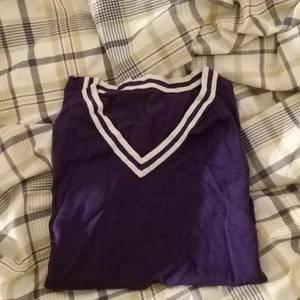 Lila sweater vest - En lila sweater vest med vita ränder längst botten och kragen. Sitter som fitted M eller loose S 