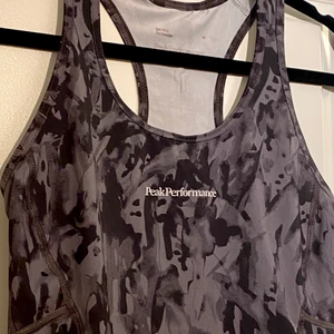 Peak performance träningslinne - Träningstopp från Peak performance, säljes då den är för liten. Lite andvänd som syns på märket på baksidan lite sprickor. linnet har en ficka på baksidan som (bild 3 visar). Skriv för fler bilder vid intresse.