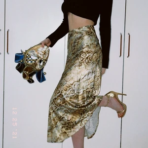 Orm mönstrad kjol - Denna kjol är i ett gulligt orm mönster. Den har ett fint flow och går jättebra att klä upp och klä ner. Den är i nyskick och knappt använd. 