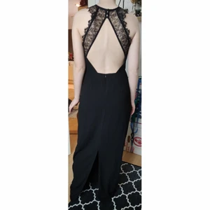 Svart lång klänning från Nly eve  - Säljer en svart och stilren långklänning från nly eve i storlek 38 med öppen rygg och spetsdetaljer. Endast använd en gång så är i mycket bra skick. Kanske kan passa till nyårsmiddagen? 