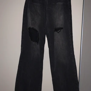 Jeans  - Svart/gråa jeans med slitningar. Raka i benen.