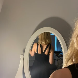 Svart klänning - Fin klänning med klockad kjol och mönstrad rygg. Knappt använd. Köpt på New Yorker.