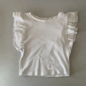 Zaratopp - En vit volangtopp från zara! Använt ganska mycket men är fortfarande i väldigt bra skick!