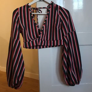 Croppad topp - Croppad fin långärmad tröja från Boohoo. I färgerna svart (mörkgrå), röd och vit. Urringning där fram och knyte i ryggen. Använd endast en gång. Står storlek 40, men påminner om en S/M. Stretchigt tyg. Frakt tillkommer 🌹