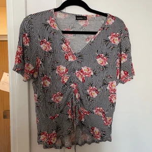 Blommig t-shirt - En blommig t-shirt med dragsko på framsidan