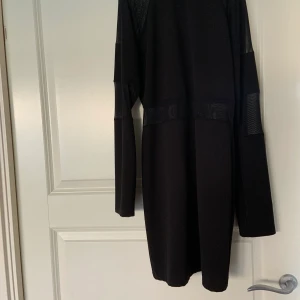 Klänning - Svart klänning från Missguided i storlek 38z genomskinlig på vissa ställen, armarna och lite bit vid magen. De är hög krage och dragkedja baktill.