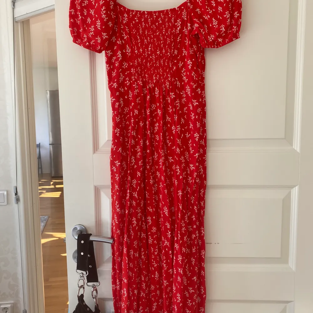 En blommig röd klänning i storlek 36 från & other stories i modellen Flowy puff sleeve Midi dress. Använd 1 gång. . Klänningar.