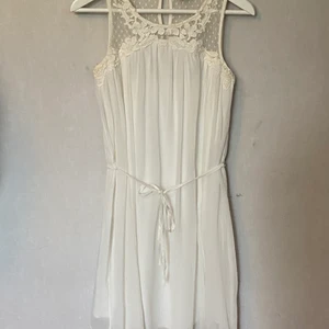 Vit klänning - Klänning ifrån Vila i storlek S. Band som man kan knyta i midjan antingen på baksidan eller framsidan. Du står för frakten.