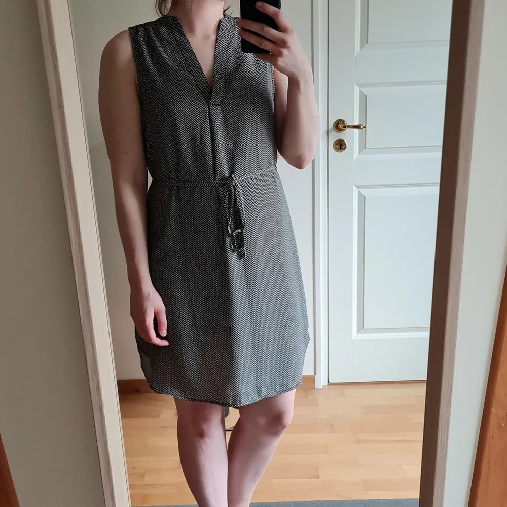 Black and beige dress from H&M. Made of a thin, flowy fabric with no sleeves and V neckline - good for summer parties 🥳 Classic color makes it good for every occasion 😊 Total length 90 cm.Total length 87 cm.. Klänningar.
