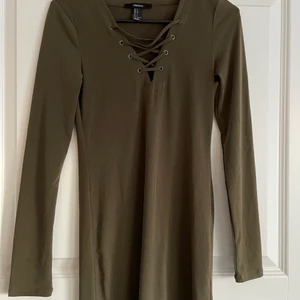 Grön klänning med snörning  - Grön klänning med snörning framtill inte blivit använd på ett bra tag men fortfarande i fint skick! 