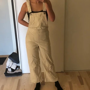 Hängselbyxor i manchester från Levi’s - Knappt använda hängselbyxor i beigefärgat manchestertyg från Levi’s. Knäpps med en dragkedja i sidan. 