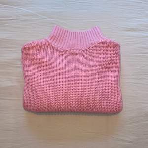 Kort, stickad tröja i den finaste rosa färgen med rund halsringning. 