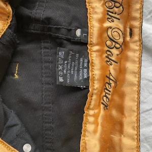 Bik Bok Venus Pensil L - Svart byxa med höga ben och snygga gulddetaljer. Längst ner sitter snygg guld dragkedja som kan öppnas, även snygga detaljer på bakfickorna, använd fåtal gånger. 