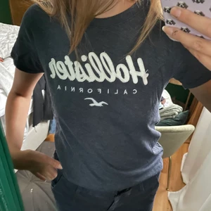 Hollister t-shirt - Väldigt fin t-shirt i en snygg mörkblå och vit färg. Tröjan är endast använd ca 2 gånger, alltså nyskick. Tröjan är i storlek S.