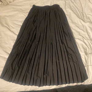 Kjol  - Svart lång kjol med resår i midjan och som strykna kanter eller hur man ska säga. Vet ej va det heter, tror det kallas för plissering. Köpte den på plick men kom aldrig till användning. En bit av en prislapp kvar på insidan (se sista bilden), har inte försökt få bort den. 