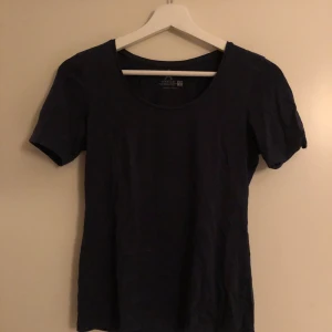 Mörkblå t-shirt - Mörkblå t-shirt från Åhléns i strl S. Den ser nästan svart ut på bilden men den är mer mörkblå lite åt det lila hållet i verkligheten.
