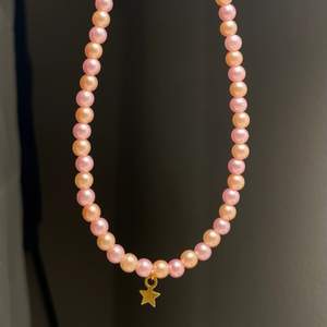 Egengjort pärlhalsband med rosa och peach färgade pärlor, och en stjärnberlock 🌟 24kr för frakten 🤍