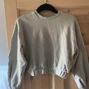 En grå croppad sweatshirt från Zara. Går mot det pastellgröna hållet! Storlek S och säljs för att den är för kort i armarna som är 182 lång 🤌🏼🤌🏼 