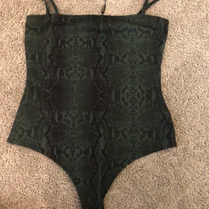 Bodysuit  - Bodysuit med ormmönster, grön väldigt skön. String syns inte igenom byxorna! Passar till allt alla aktiviteter. Aldrig andvänd