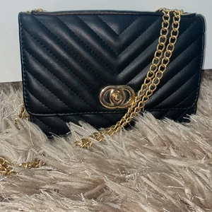 En svart och guldig fin väska - Säljer för att använda inte den ofta 