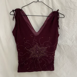 linne - v-skuret linne som är skitfint till sommar eller fest. i en vinröd färg med guld på trycket. band på axlarna som reglerar hur bred ärmen är:)