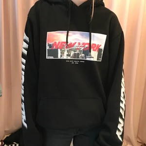 Svart hoodie med tryck - Svart hoodie från H&M divided herravdelning. Tryck på framsida, baksida och båda ärmar. Bra skick, ser knappt använd ut, stl L