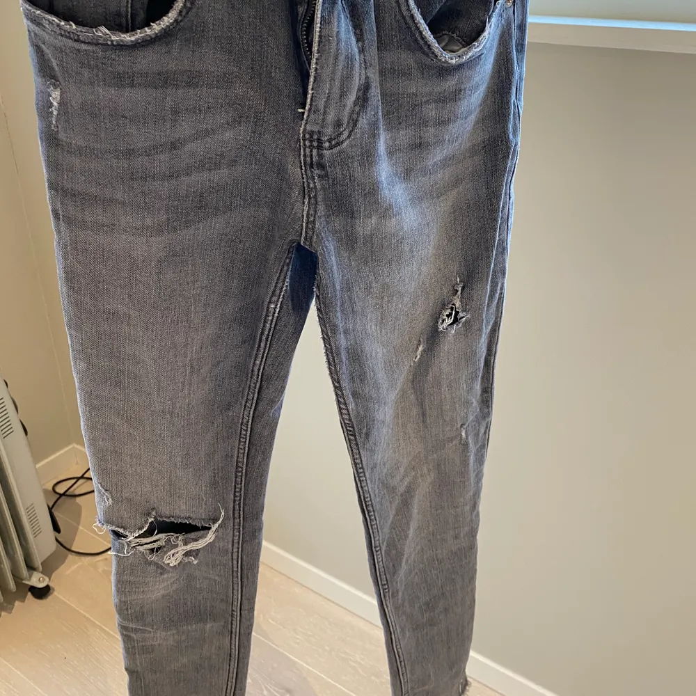Ett par gråa zara jeans med hål på högra knät och ett mindre hål på det vänstra låret. Aldrig använda men begagnade av en kompis! . Jeans & Byxor.
