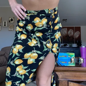 Kjol med slits - Säljer nu men härliga kjol med slits!! Den är svart med söta citroner på!! Kund står för frakt 