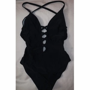 Svart baddräkt med låg rygg - Svart baddräkt med låg rygg och snörning från Hot Anatomy. Storlek S. Använd en gång. (Råkade slå på budgivning men säljer den för 100kr)