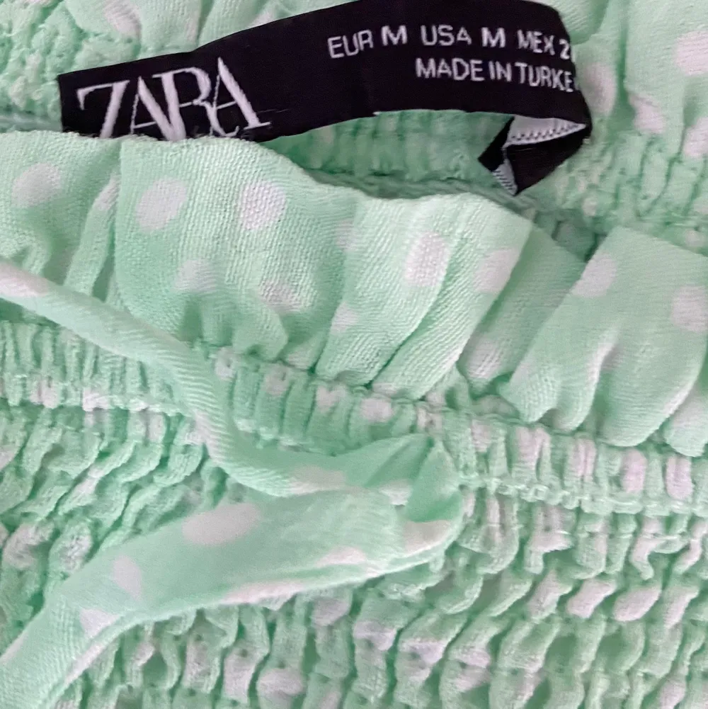 Jättesöt Croptop från ZARA i ljusgrön färg strl M, passar dig som är S-M i strl använd 3 ggr så fint skick! sydd med smock och är stretchig i plagget. Jättefin till sommaren då man ser brun ut i färgen! Färgen är mest rättvis på bild 1 & 2.   https://www.tradera.com/item/525682203. Toppar.