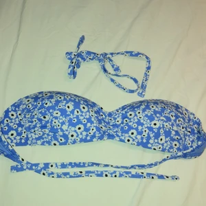 Blommig bikiniöverdel  - Bikiniöverdel som är ”fodrad” från Lindex i storlek 36, bandeau modell, med snörning i ryggen. Avtagbara band finns med. Lite liten i storleken så skulle säga att den är ett mellanting av 34/36. Helt oanvänd 
