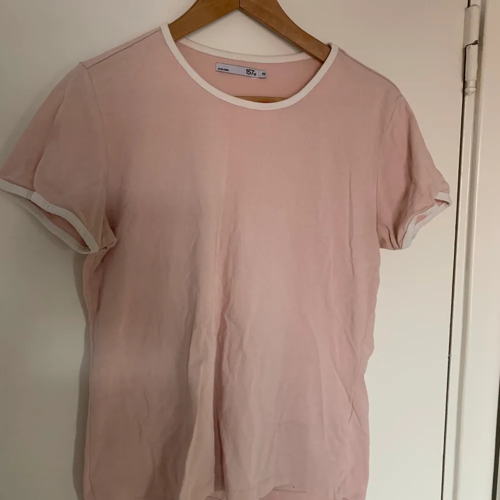 Säljer denna fina ljusrosa T-shirt som jag köpt på lager 157. Den kommer aldrig till användning så är nästan som helt ny. Den har vita sömmar vid halsen och ärmarna🥰. T-shirts.